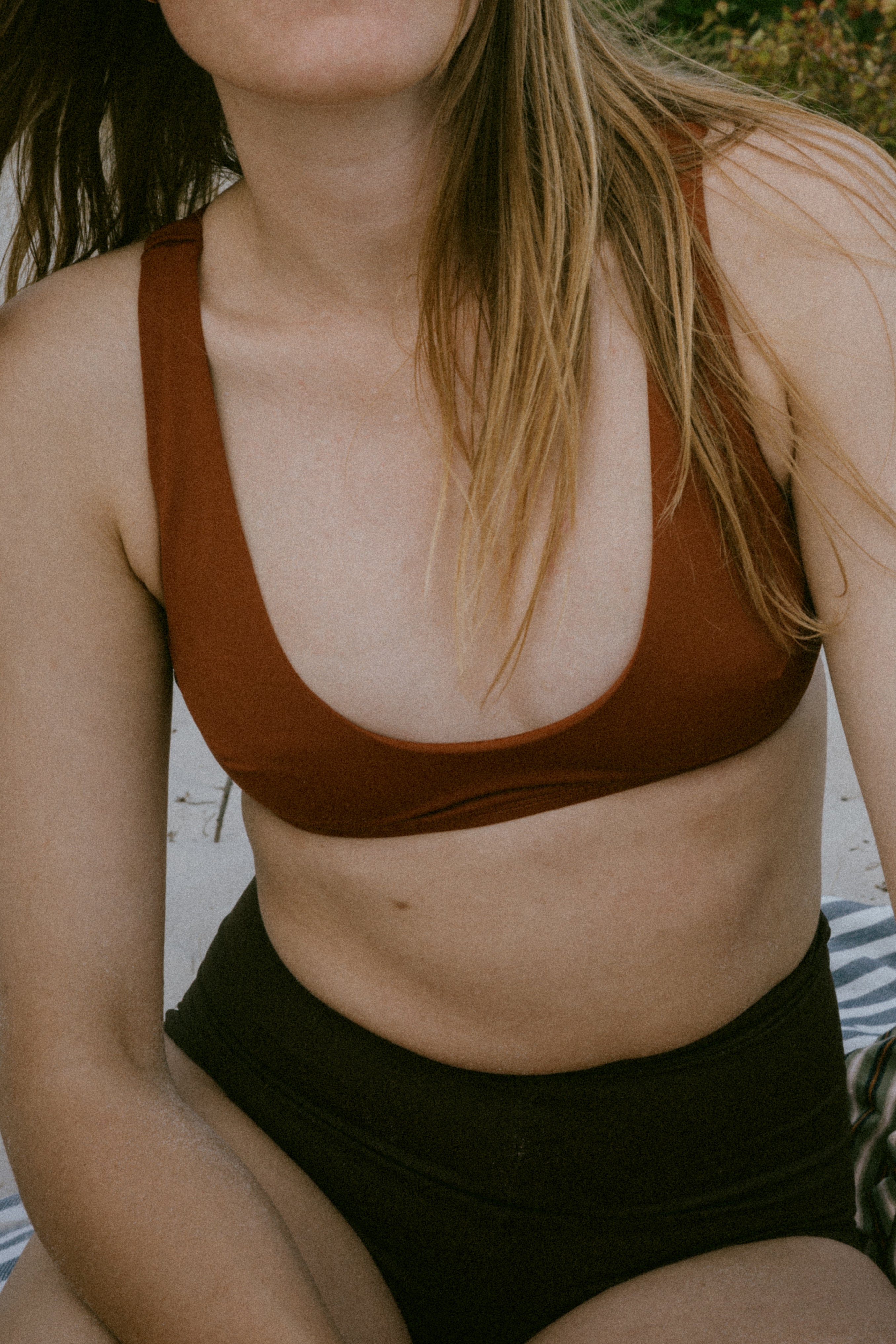 Elegant and resilient—Tumla’s true burnt orange, worn by a brunette, is designed to move seamlessly with you, ensuring comfort and style at every turn.