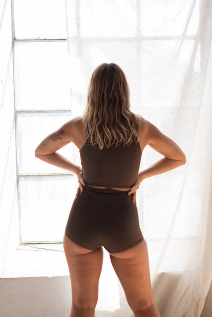 Stylish brown bikini by Tumla, worn by a brunette, designed to stay secure and flexible while surfing