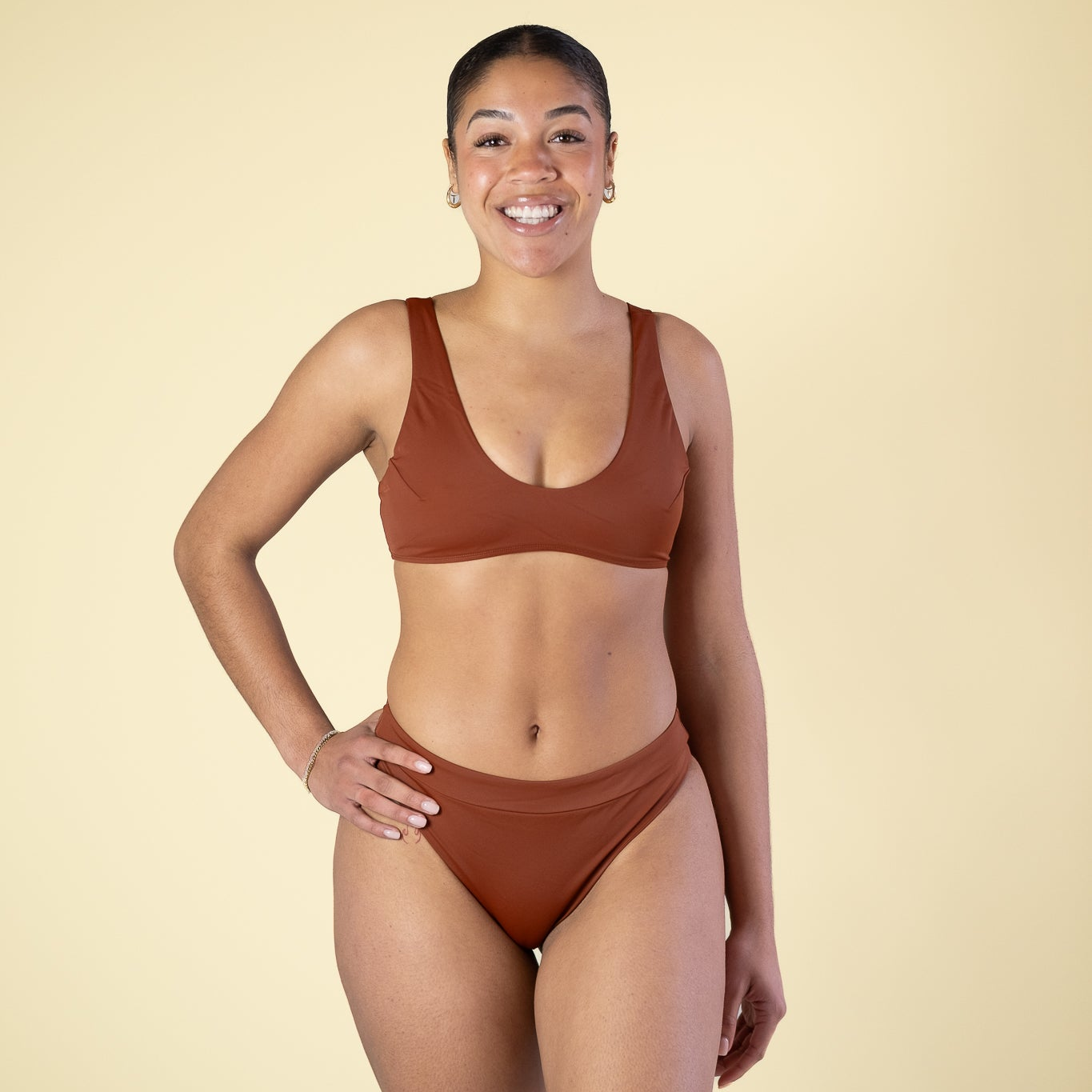 Woman wearing a brown bikini set on a beige background